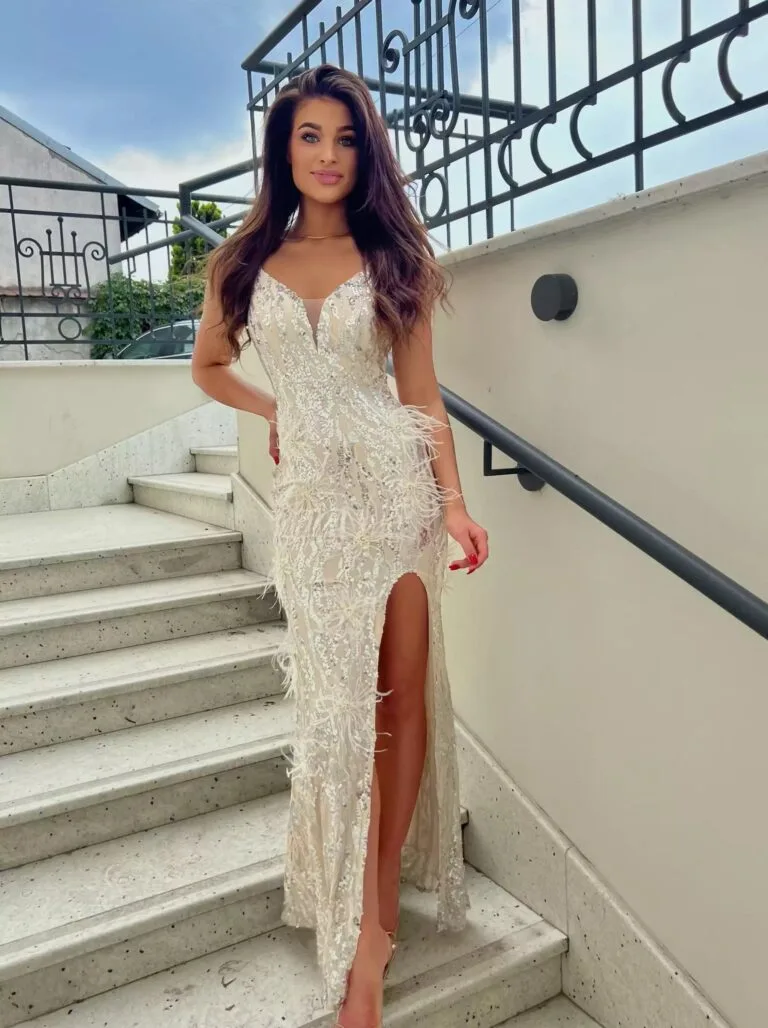 Beżowa sukienka na wesele Pusia Bis długa, zdobiona srebrnymi cekinami i piórami – glamour 2025